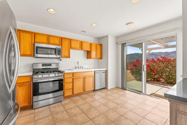 a kitchen with stainless steel appliances granite countertop a stove a sink and a refrigerator