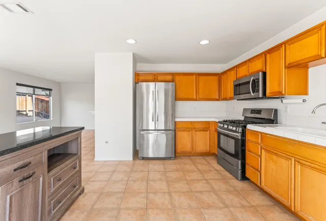 a kitchen with a sink a counter top space and stainless steel appliances