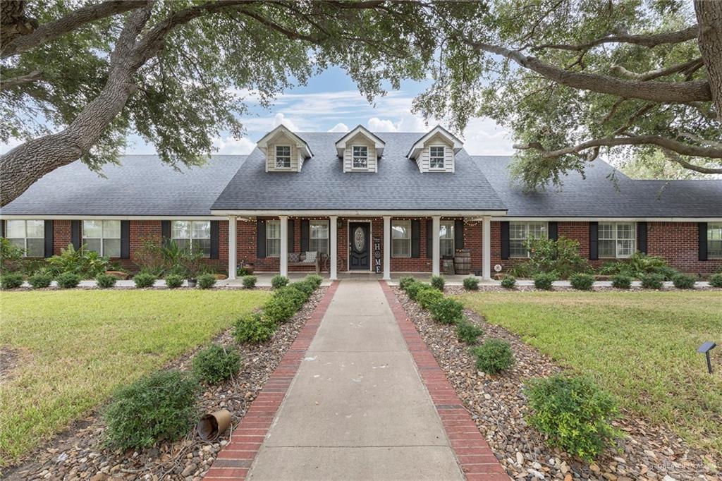 1902 Sundance Street Palmhurst, TX 78573 - Photo 2 of 43 a view of a brick house with a big yard plants and large trees