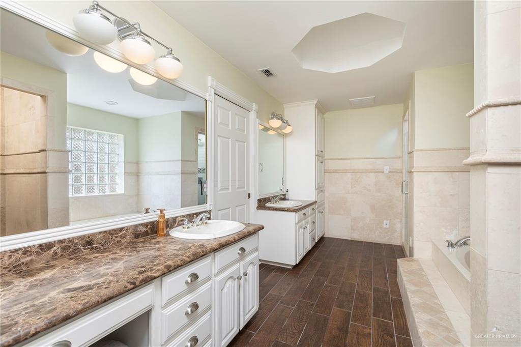 1902 Sundance Street Palmhurst, TX 78573 - Photo 22 of 43 a bathroom with a granite countertop double vanity sink a mirror and a shower