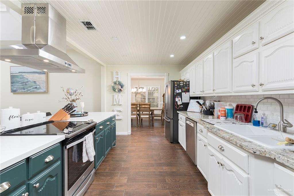 1902 Sundance Street Palmhurst, TX 78573 - Photo 10 of 43 a kitchen with stainless steel appliances granite countertop lots of counter top space and wooden floors