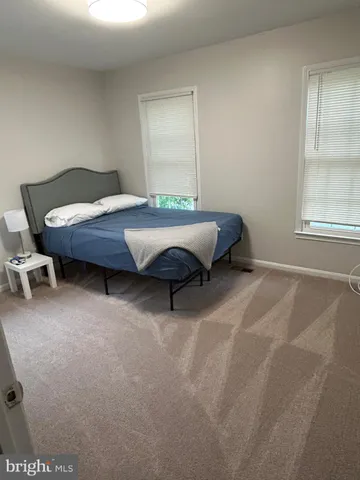 a bed sitting in a bedroom next to a window