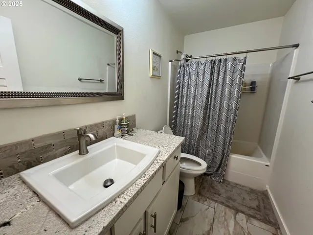 a bathroom with a sink a toilet and a mirror