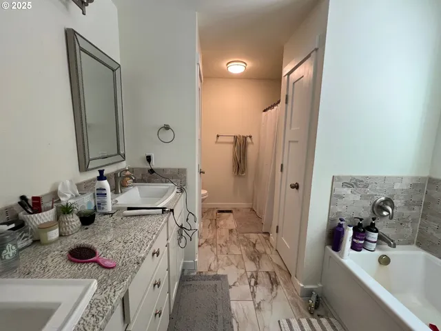 a bathroom with a tub sink and mirror