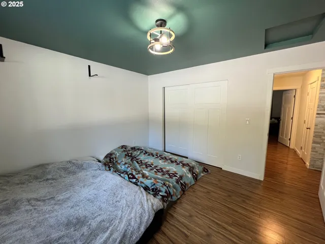 a bedroom with bed and wooden floor