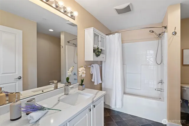 a bathroom with a tub sink and mirror