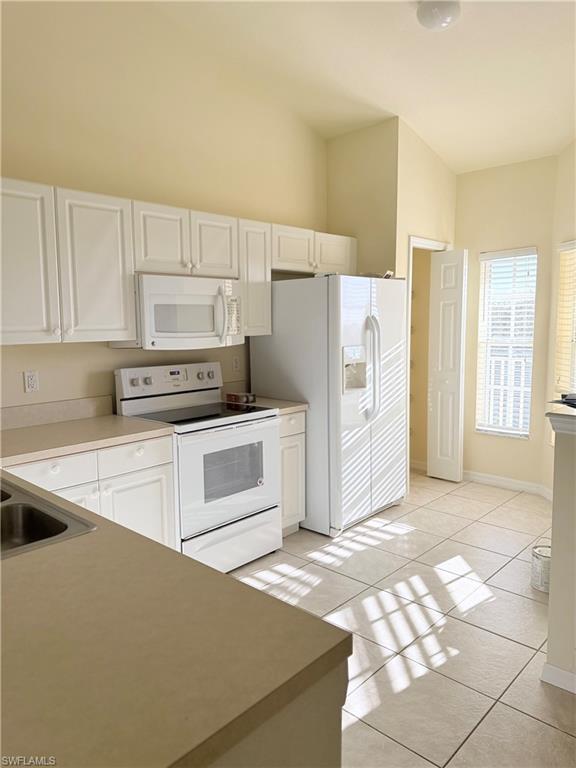 9175 Celeste Drive, Unit 2 Naples, FL 34113 - Photo 2 of 13 a kitchen with stainless steel appliances a refrigerator sink and cabinets