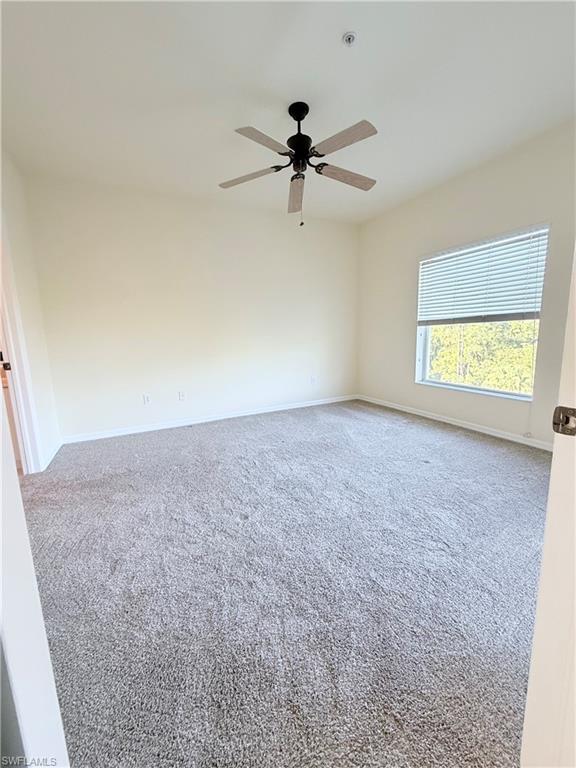 9175 Celeste Drive, Unit 2 Naples, FL 34113 - Photo 4 of 13 an empty room with windows and fan