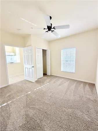 an empty room with windows and fan