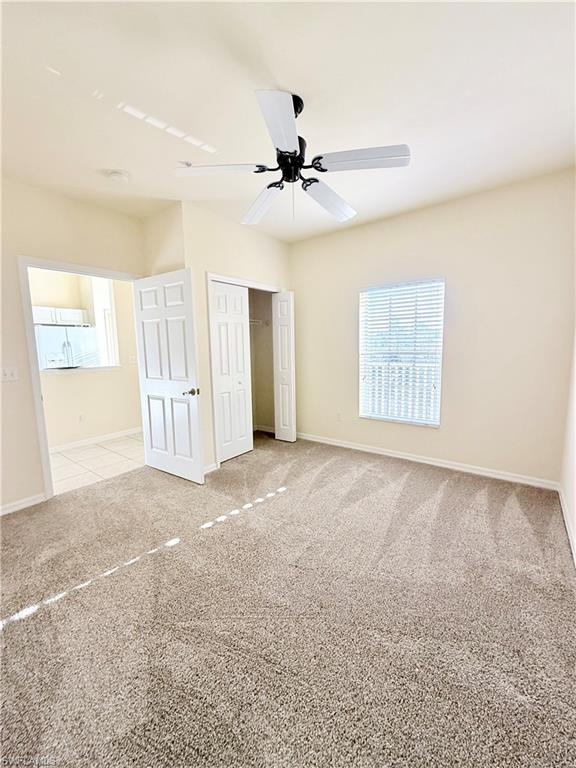 9175 Celeste Drive, Unit 2 Naples, FL 34113 - Photo 8 of 13 an empty room with windows and fan