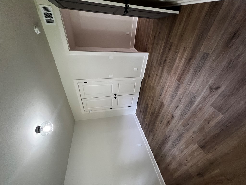 213 Carter Road Pottsville, AR 72858 - Photo 17 of 41 Bedroom 2; Spacious room featuring wood-finish LVP flooring, white walls, and a ceiling-mounted light fixture