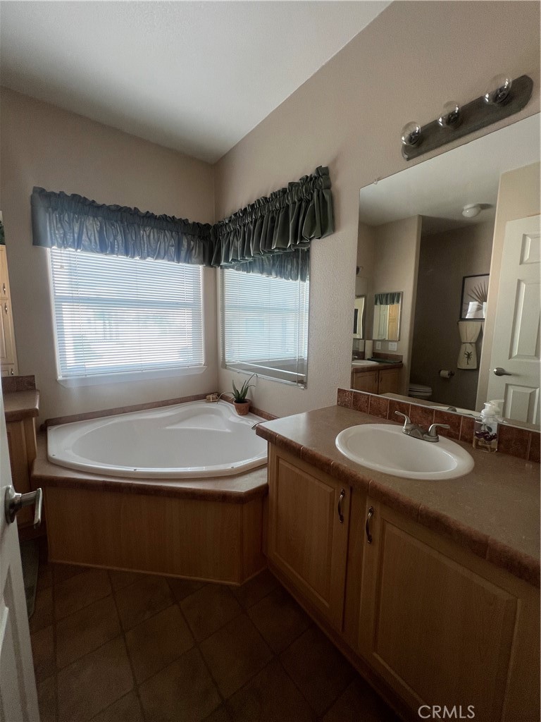 1189 Marina Drive Needles, CA 92363 - Photo 20 of 26 a bathroom with a double vanity sink a mirror and a bathtub