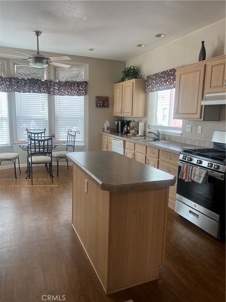 1189 Marina Drive Needles, CA 92363 - Photo 10 of 26 a kitchen with stainless steel appliances granite countertop a stove top oven a sink a dining table and chairs with wooden floor