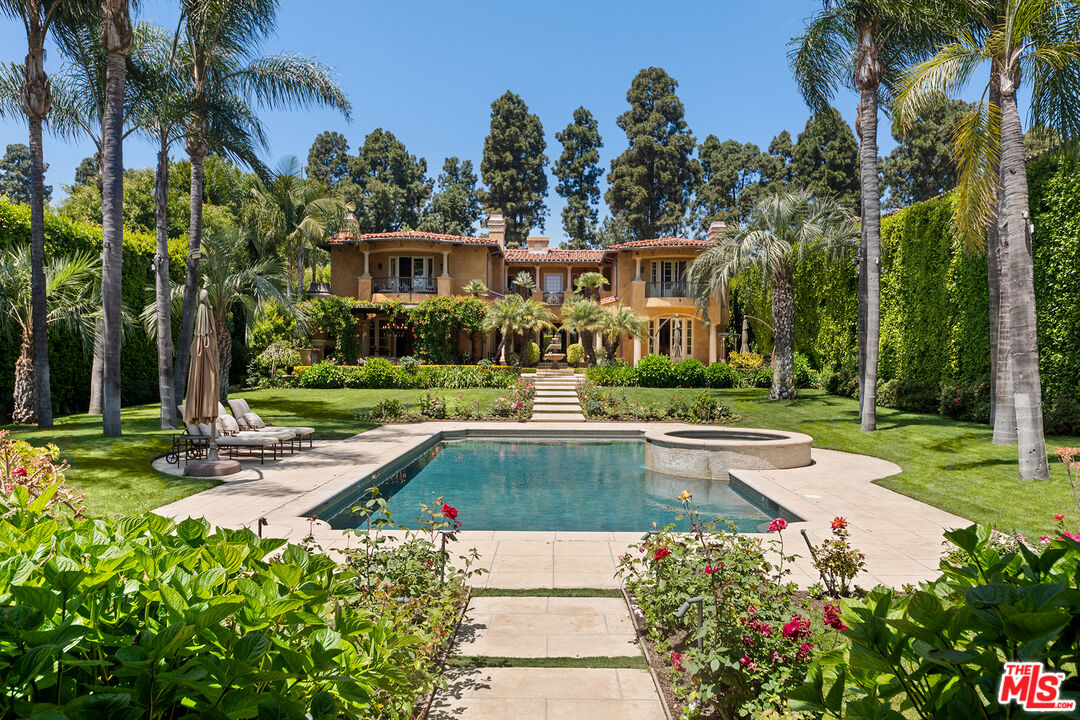 a view of a house with swimming pool and a garden