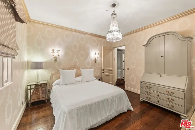 a spacious bedroom with a bed and wooden floor