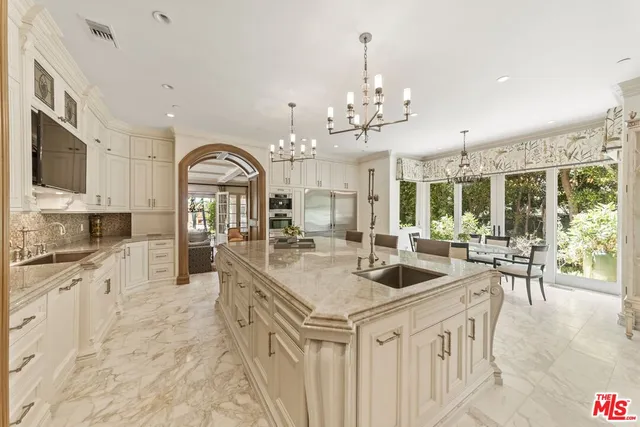 a large kitchen with granite countertop a lot of counter space and living room