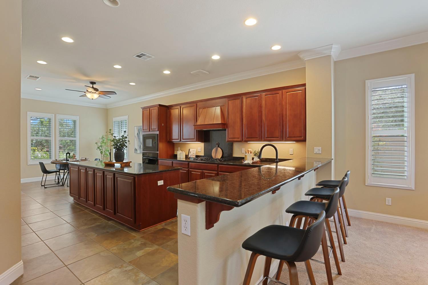 2439 Appleleaf Lane Manteca, CA 95336 - Photo 20 of 73 a kitchen with granite countertop a sink and chairs