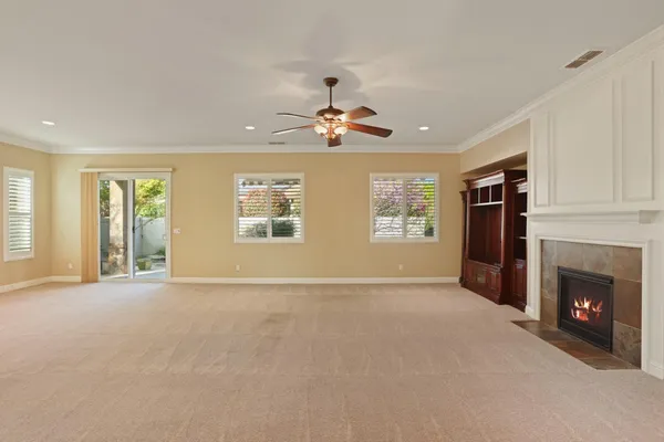 a view of an empty room with a fireplace and a window