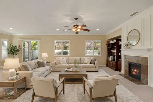 a living room with furniture a fireplace and a large window