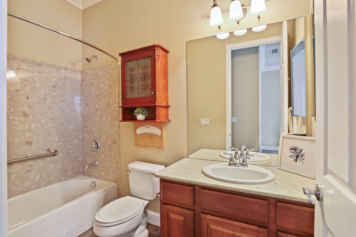2439 Appleleaf Lane Manteca, CA 95336 - Photo 33 of 73 a bathroom with a sink a toilet a mirror a bathtub and shower