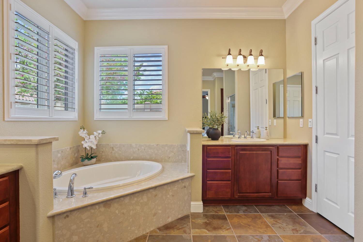 2439 Appleleaf Lane Manteca, CA 95336 - Photo 37 of 73 a bathroom with a tub sink and mirror
