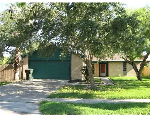 a view of a house with backyard and tree