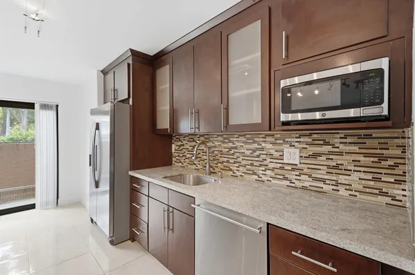 a kitchen with stainless steel appliances granite countertop a sink and a microwave