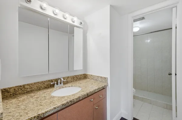a bathroom with a granite countertop sink and mirror