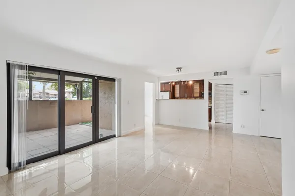 a view of a big room with wooden floor and windows