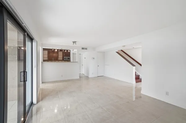 a view of a livingroom with an empty space and a refrigerator