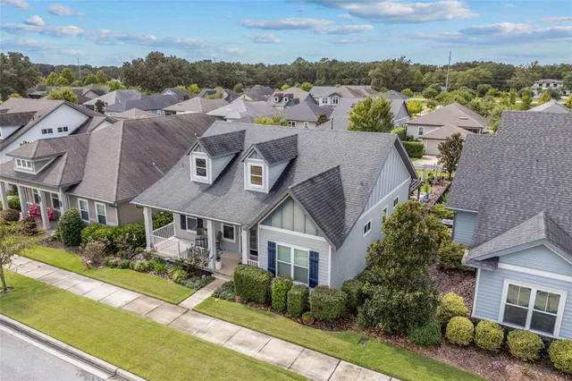 an aerial view of a house with a garden and lake view