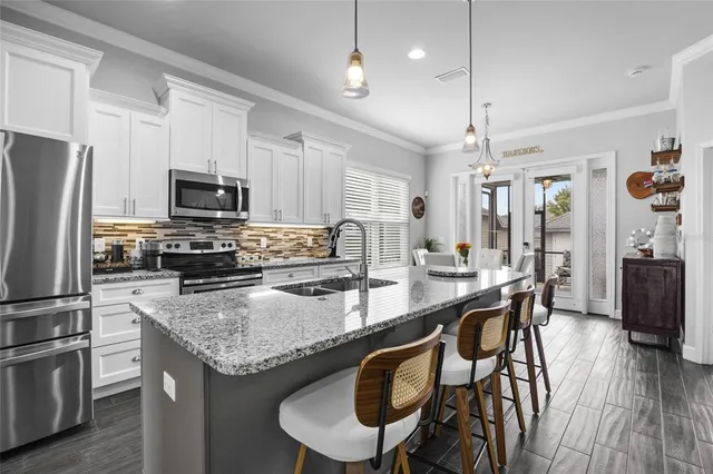 a kitchen with granite countertop kitchen island wooden cabinets and stainless steel appliances
