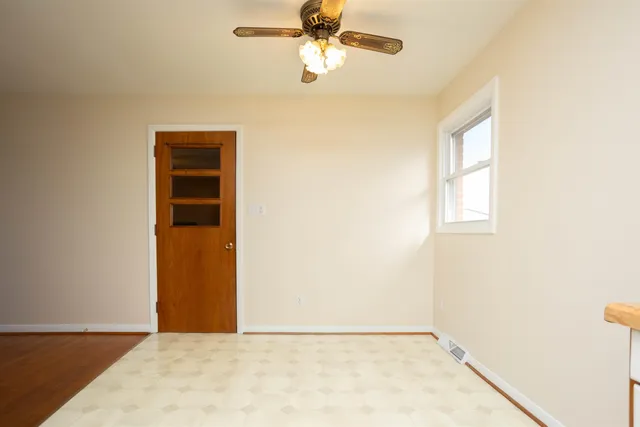 an empty room with a window and a ceiling fan