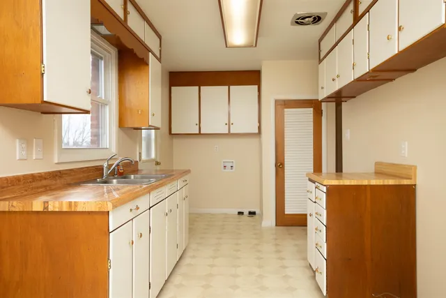 a kitchen with a granite countertop sink a stove a refrigerator and a window