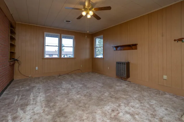 en empty room with windows and ceiling fan
