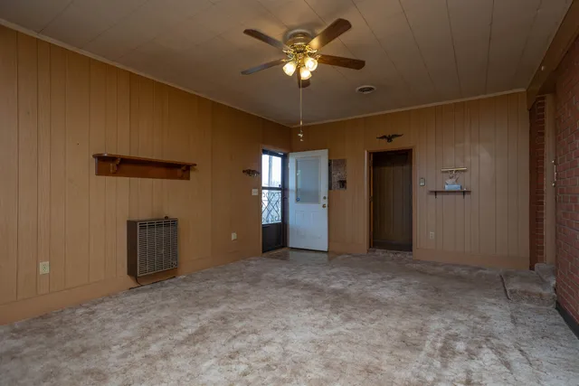 an empty room with closet and a chandelier fan