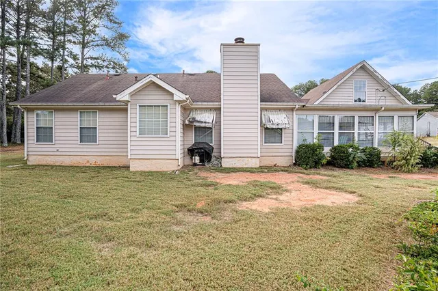 a view of a house with backyard and trees
