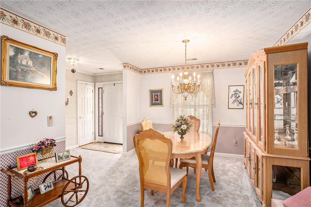 30 Spring Valley Drive Covington, GA 30016 - Photo 8 of 28 a dining room with furniture a chandelier and wooden floor