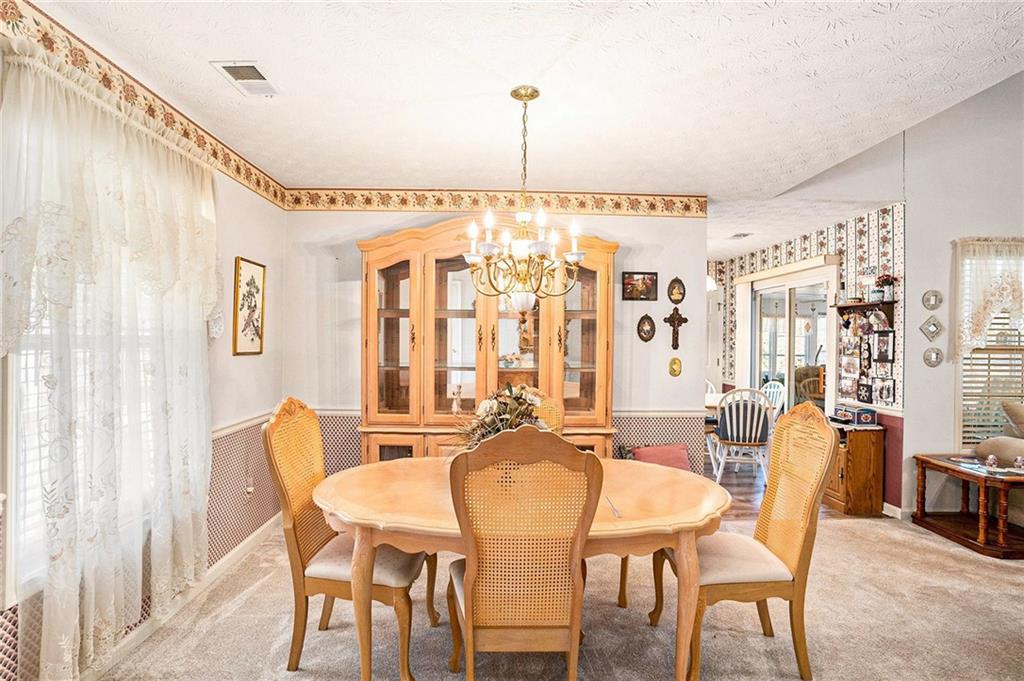 30 Spring Valley Drive Covington, GA 30016 - Photo 9 of 28 a dining room with furniture a chandelier and wooden floor