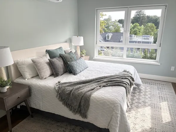 a bedroom with a bed and a large window