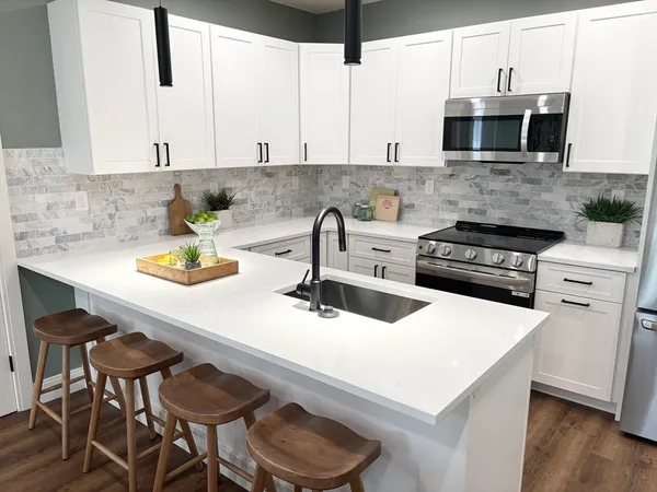 a kitchen with stainless steel appliances a stove a sink and a microwave