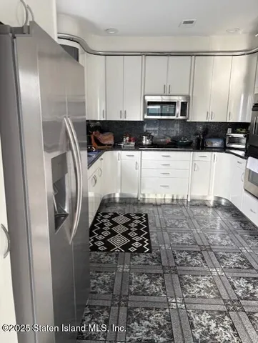 a kitchen with granite countertop a sink a stove and cabinets