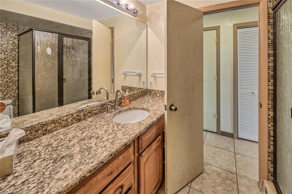 29 Caribbean Road Naples, FL 34108 - Photo 21 of 32 Bathroom with tile patterned flooring, vanity, and an enclosed shower
