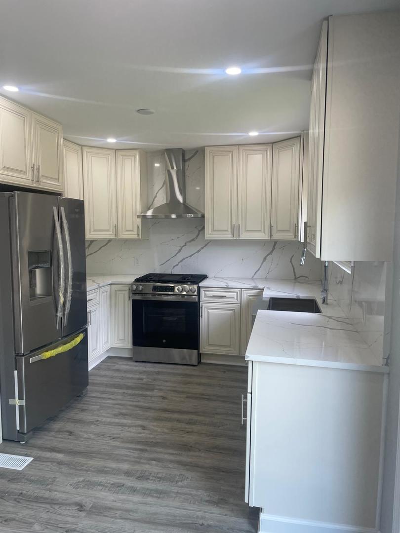 573 Redwood Road Bolingbrook, IL 60440 - Photo 5 of 24 a kitchen with stainless steel appliances granite countertop a sink a stove a refrigerator and a oven