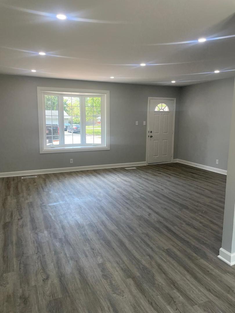 573 Redwood Road Bolingbrook, IL 60440 - Photo 9 of 24 an empty room with wooden floor and windows