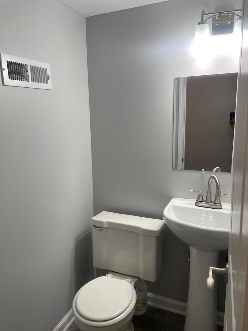 573 Redwood Road Bolingbrook, IL 60440 - Photo 10 of 24 a white toilet sitting next to a bathroom sink