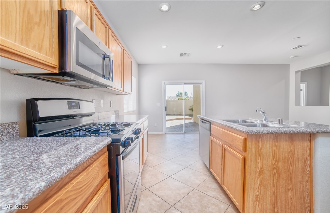 4020 Spring Line Street North Las Vegas, NV 89032 - Photo 9 of 29 Kitchen with appliances with stainless steel finishes, recessed lighting, a kitchen island with sink, light brown cabinetry, and light tile patterned floors
