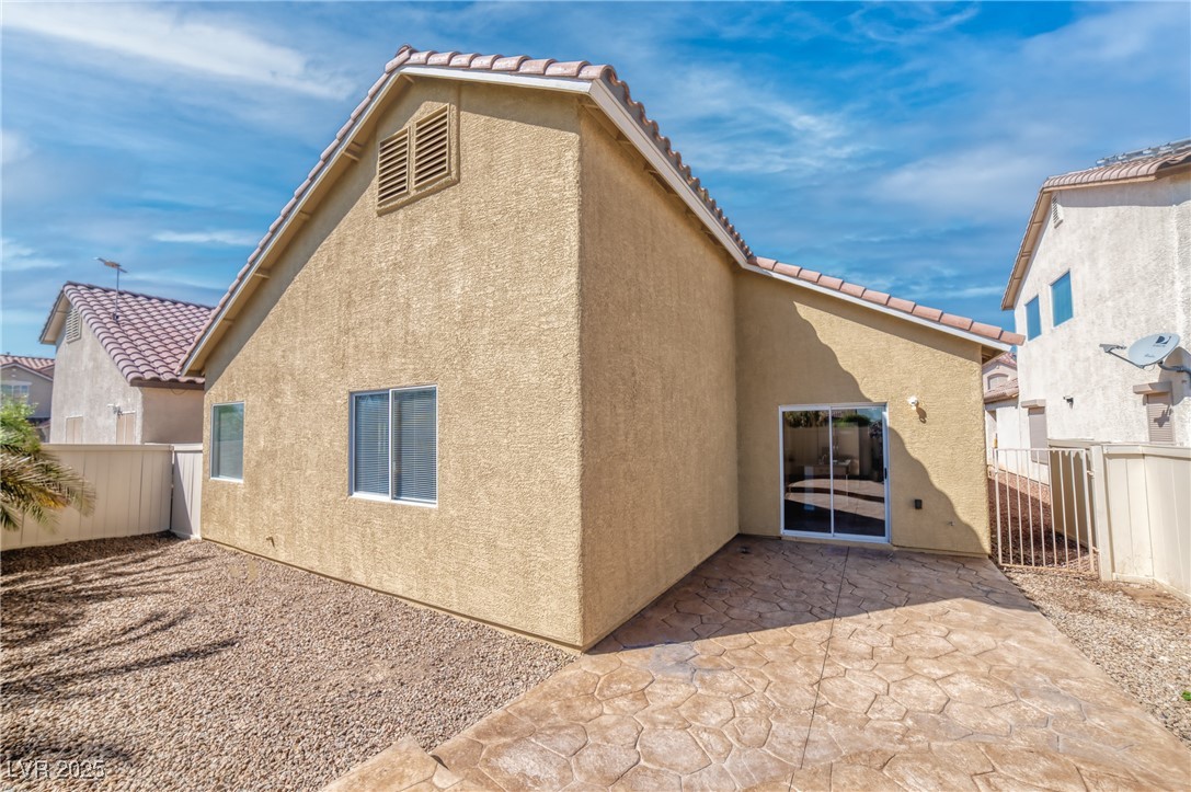 4020 Spring Line Street North Las Vegas, NV 89032 - Photo 22 of 29 Rear view of house featuring a fenced backyard, a tiled roof, stucco siding, and a patio area