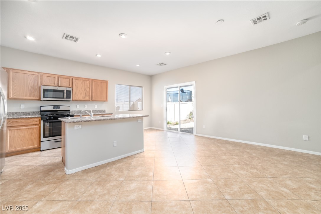 4020 Spring Line Street North Las Vegas, NV 89032 - Photo 28 of 29 Kitchen featuring stainless steel appliances, a kitchen island with sink, light stone countertops, recessed lighting, and open floor plan