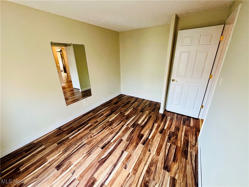 1747 Sterling Road Madison, OH 44057 - Photo 20 of 40 Unfurnished room with dark hardwood / wood-style floors and a textured ceiling